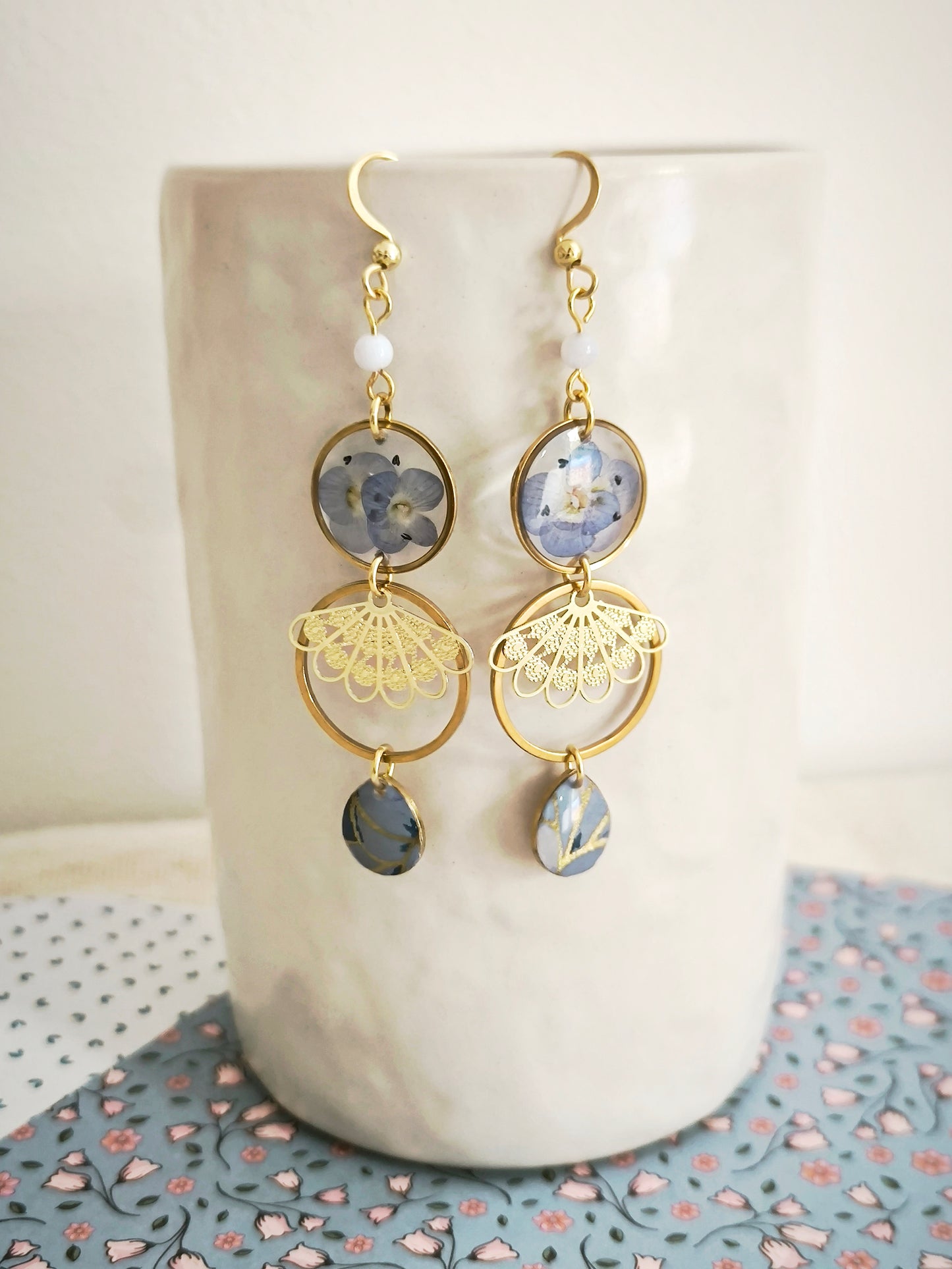 Boucles d’oreilles florales en résine – fleurs bleues & acier doré