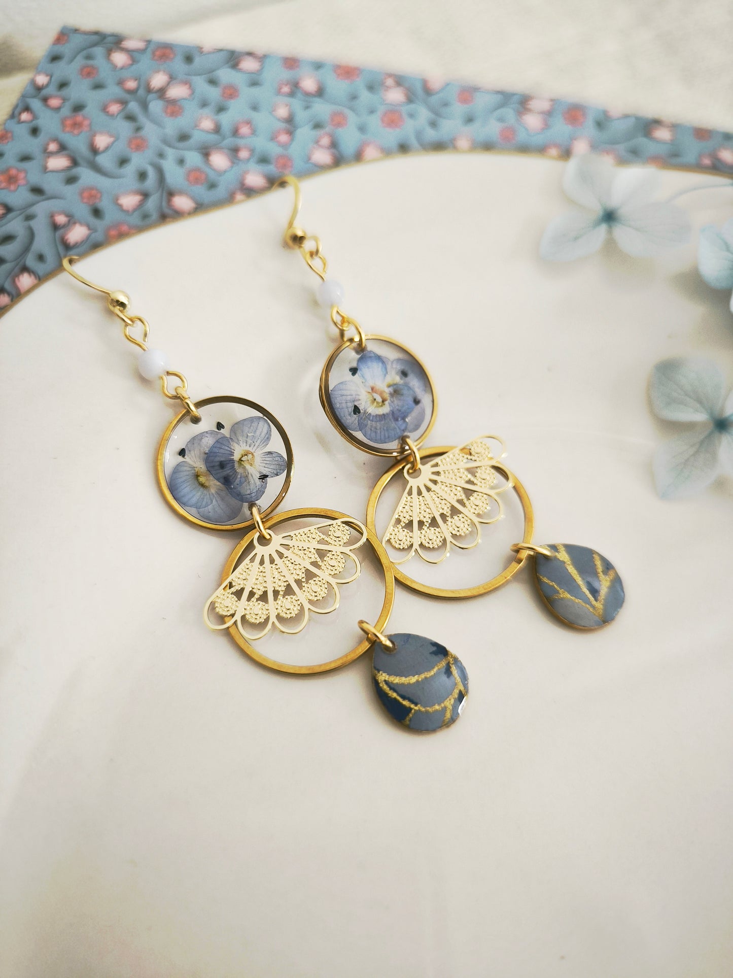 Boucles d’oreilles florales en résine – fleurs bleues & acier doré